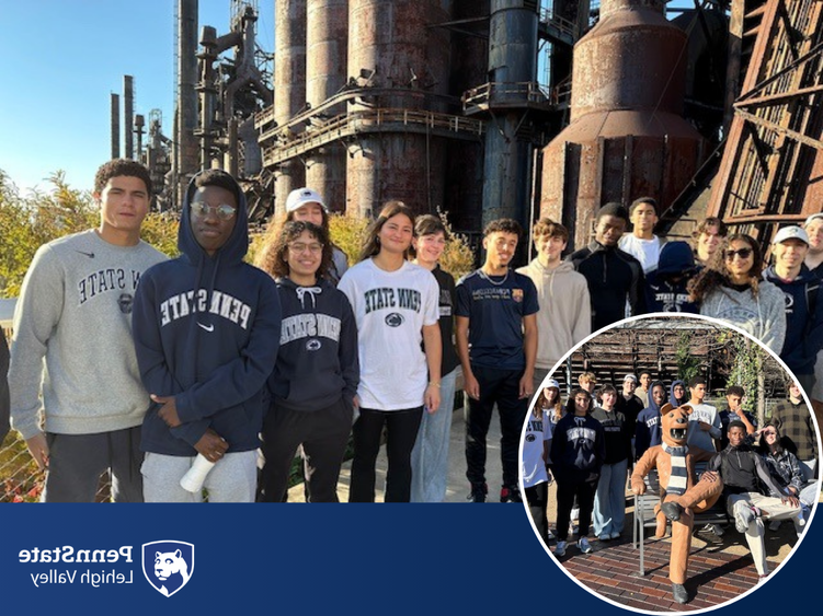 students wearing Penn State shirts smile while standing in front of Bethlehem SteelStacks